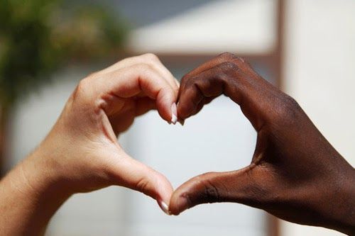 Black and white hands making heart